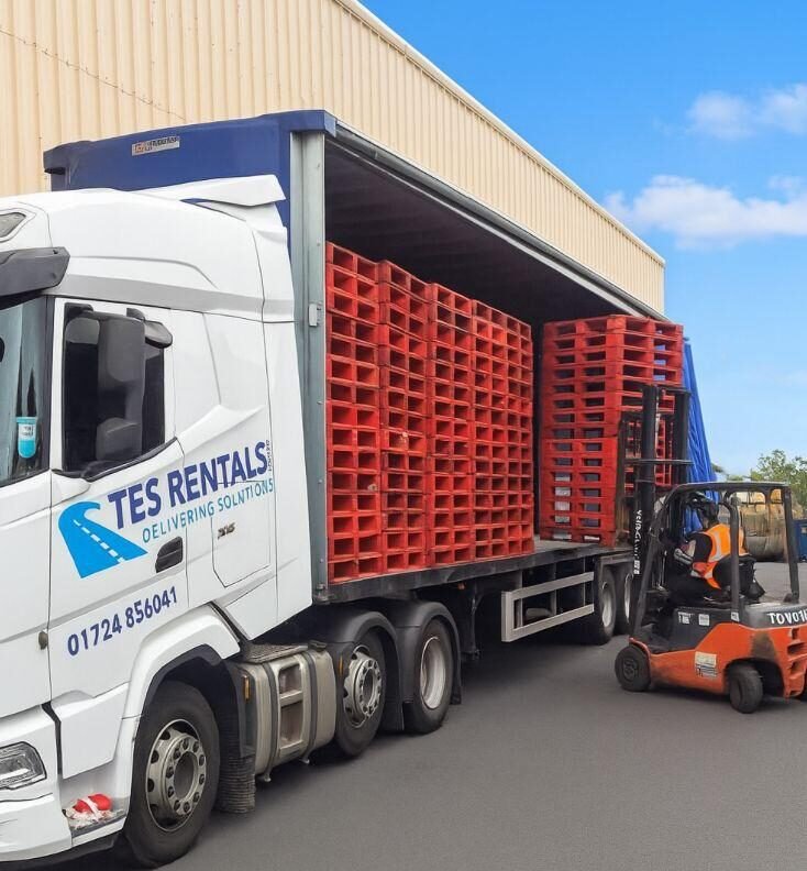 TES curtainsider loaded with pallets, forklift alongside